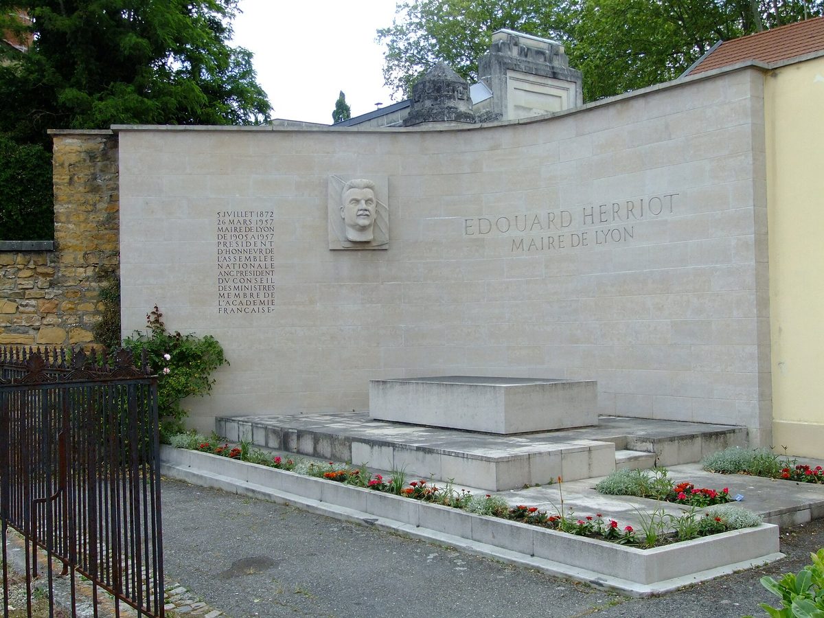Mur funéraire en pierre claire portant un médaillon sculpté et l’inscription Édouard Herriot, maire de Lyon